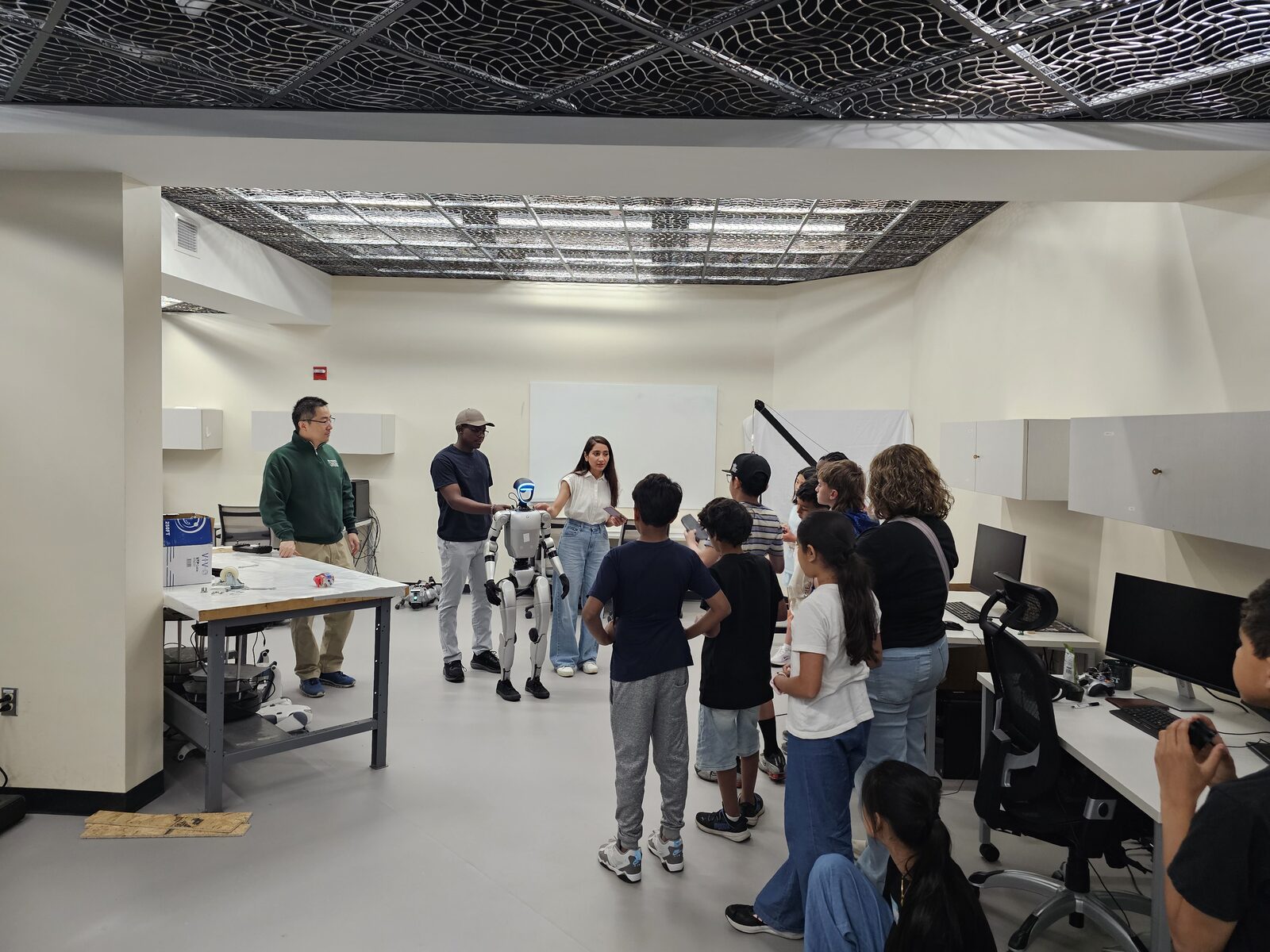 Demonstrating the humanoid robot to students during the lab tour
